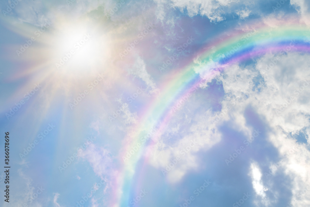 Wall mural summer sun burst and blue sky rainbow - massive sun radiating beside fluffy clouds with a giant arci