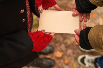 Couple holding an empty vintage sheet of paper in their hands