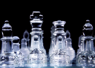 The king and the queen, transparent pieces of the game of chess, over a glass chessboard. Seen from...