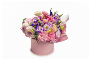 Pink and purple bouquet of flowers in a pink box isolated on white.