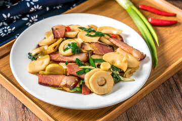 A plate of winter bamboo shoots bacon on a wooden table