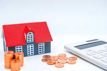 House model, calculator, coins on white background-concept of buying house