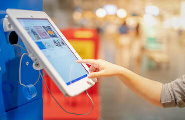 Female hand touching the tablet monitor in side the public area for the get the information or...