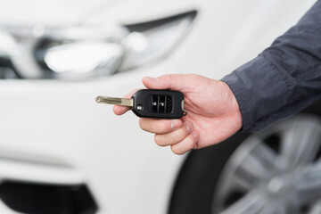 Close up car keys and remote control car alarm systems hold in hand. Young man buy the new car.