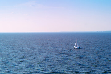 Sailboat in the sea in the evening sunlight over sky background. Luxury summer adventure or active...