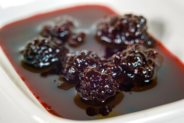 Close up view of a blackberry jam in the white plate,