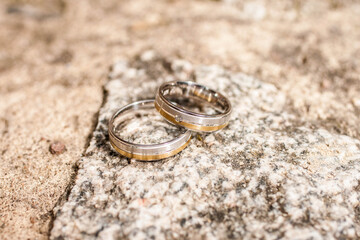 Obraz na płótnie Canvas Wedding silver golden rings on a stone
