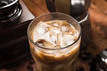 close up view of ice cubes in cold brewed coffee in glass on dark background