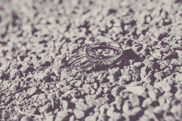 Wedding silver rings on gravel in black and white