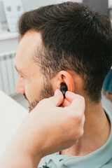 Mixed race man having a hearing test with special medical equipment. Impedance audiometry,...