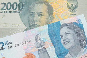 A macro image of a grey two thousand Indonesian rupiah bank note paired up with a blue two thousand bank note from Colombia.  Shot close up in macro.