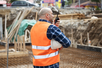 Worker, engineer,communicates with the headquarters on the construction site