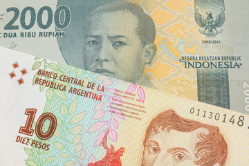 A macro image of a grey two thousand Indonesian rupiah bank note paired up with a colorful ten peso note from Argentina.  Shot close up in macro.