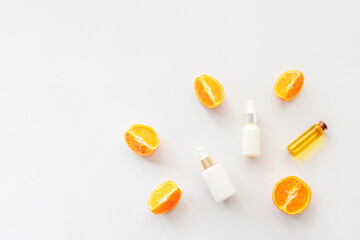 Orange essential oil and cosmetic serums isolated on white background, top view, flat lay. Natural cosmetics concept
