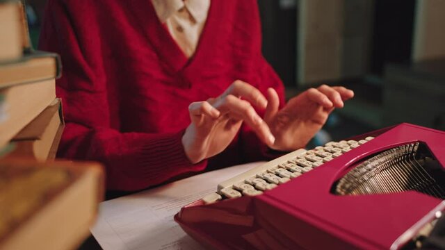Dark office typing woman fingers details on the typewriter