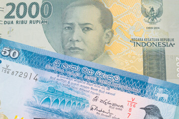 A macro image of a grey two thousand Indonesian rupiah bank note paired up with a blue and white fifty rupee bank note from Sri Lanka.  Shot close up in macro.