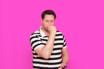Caucasian man wearing casual striped t-shirt standing over isolated hot pink background shows...
