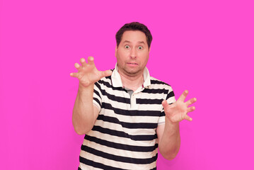 Caucasian man wearing casual striped t-shirt standing over isolated hot pink background shows...