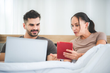 couple working on bed with laptop and tablet, work from home concept