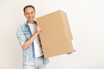 smiling delivery man holding a big parcel isolated on white