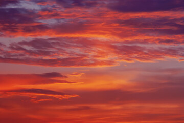 Naklejka na ściany i meble red orange purple colorful clouds in darkening sky at sunset