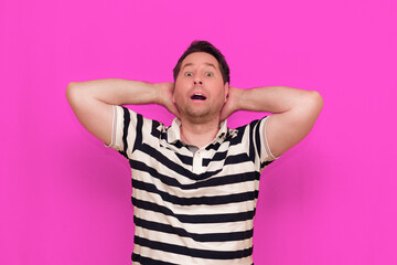 Caucasian man wearing casual striped t-shirt standing over isolated hot pink background shows...
