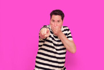 Caucasian man wearing casual striped t-shirt standing over isolated hot pink background shows...