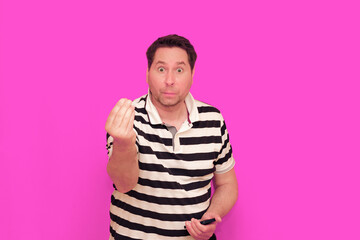 Caucasian man wearing casual striped t-shirt standing over isolated hot pink background shows...
