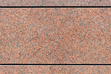 Detail of red granite plates on a building and in close up. 