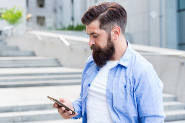 Online chat. Hipster chat via smartphone outdoors. Live chat. Real time text chat rooms. Chatting app. Instant messaging. SMS texting. New technology. 3G. 4G. Modern life. Mobile communication