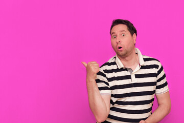 Caucasian man wearing casual striped t-shirt standing over isolated hot pink background shows various gestures.