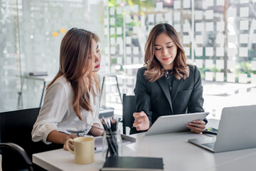 Obraz premium Two young asian businesswoman talking and working together at office.