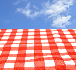 Tablecloth checkered red and white texture background and blue sky with clouds