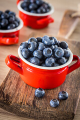 Fresh blueberries in a pot on the table, old wood