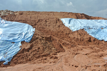 SEREMBAN, MALASIA - MARCH 3, 2019: The plastic sheet is spread over the surface of the slope to...