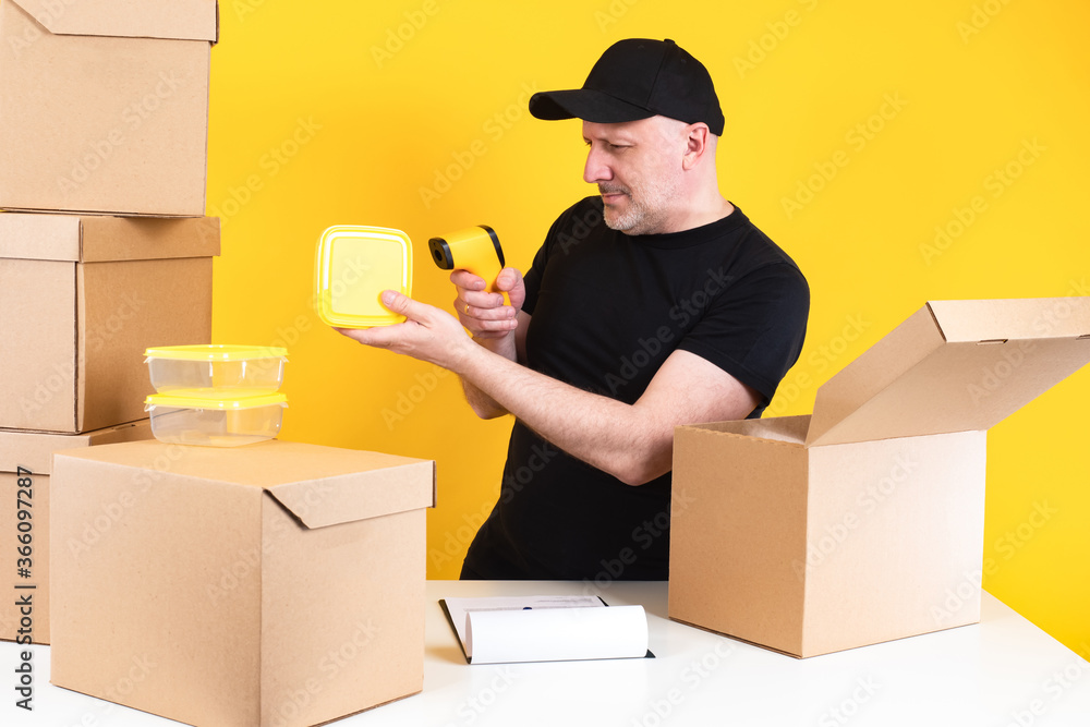 Poster warehouse worker with barcode reader. cardboard boxes are on the table. warehouse worker holds a pla