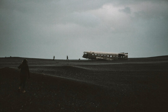 Young Female hiker walking towards famous Icelandic plane wreck