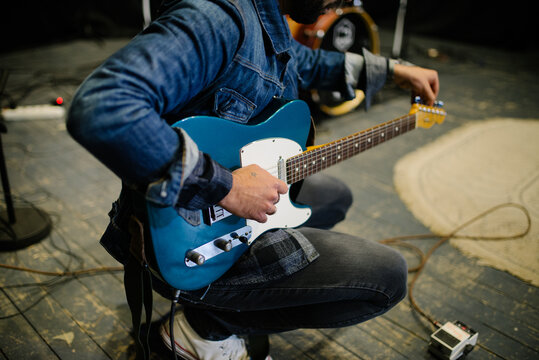 Young guitarist tunes at thr concert.