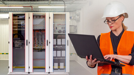 Woman next to a server cabinet. Girl with a laptop in a server room. Concept - network configuration services. Woman works as a system administrator. Woman sets up network equipment. Server setup