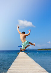 Fototapeta na wymiar Happy Man Jumping on a Dock