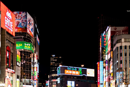 Tokyo, Japan - April 3, 2019: Shinjuku ward downtown near Kabukicho street road with neon colorful illuminated city lights cityscape skyline and advertisements against black sky night