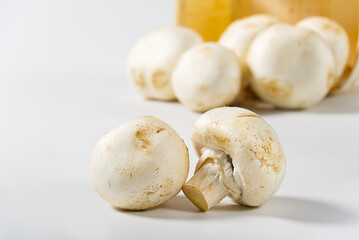 White Mushrooms champignons in wooden basket on a light background. Close up with copy space. Packed champignons to basket.