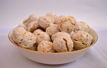 Homemade gingerbread cookies in a porcelain bowl against the background of a linen tablecloth and perekatipole flowers
