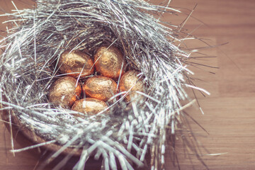 Silver nest with rose golden eggs, chocolates for Easter party
