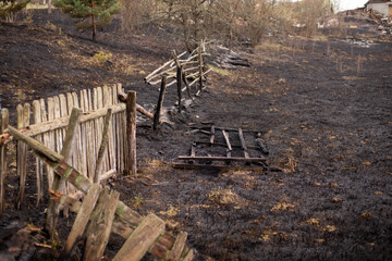 Burned grass and fence of the private property in the countryside. Concept of uncontrolled fire