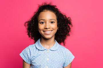 smiling cute curly african american kid isolated on pink