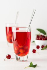 Summer delicious cherry compote with pulp in glasses on a white background