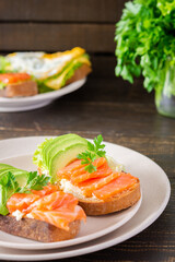 Different delicious sandwiches for breakfast, bread with cheese, avocado and trout, sandwich with egg and parsley