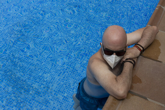 Man with medical mask in a swimming pool