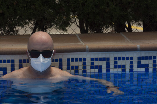 Man with medical mask in a swimming pool